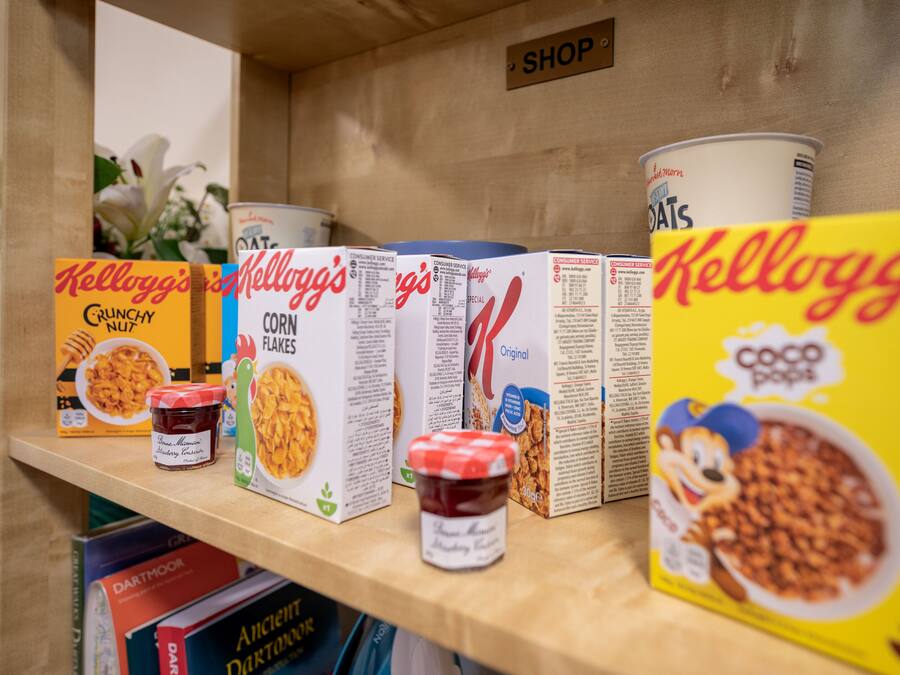 Cereal boxes and jars on a shelf.