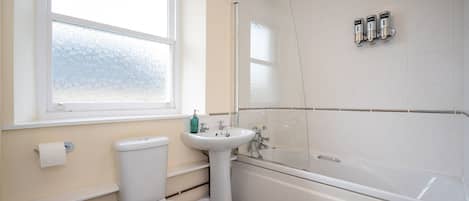 A bathroom with a toilet, sink, and bathtub.