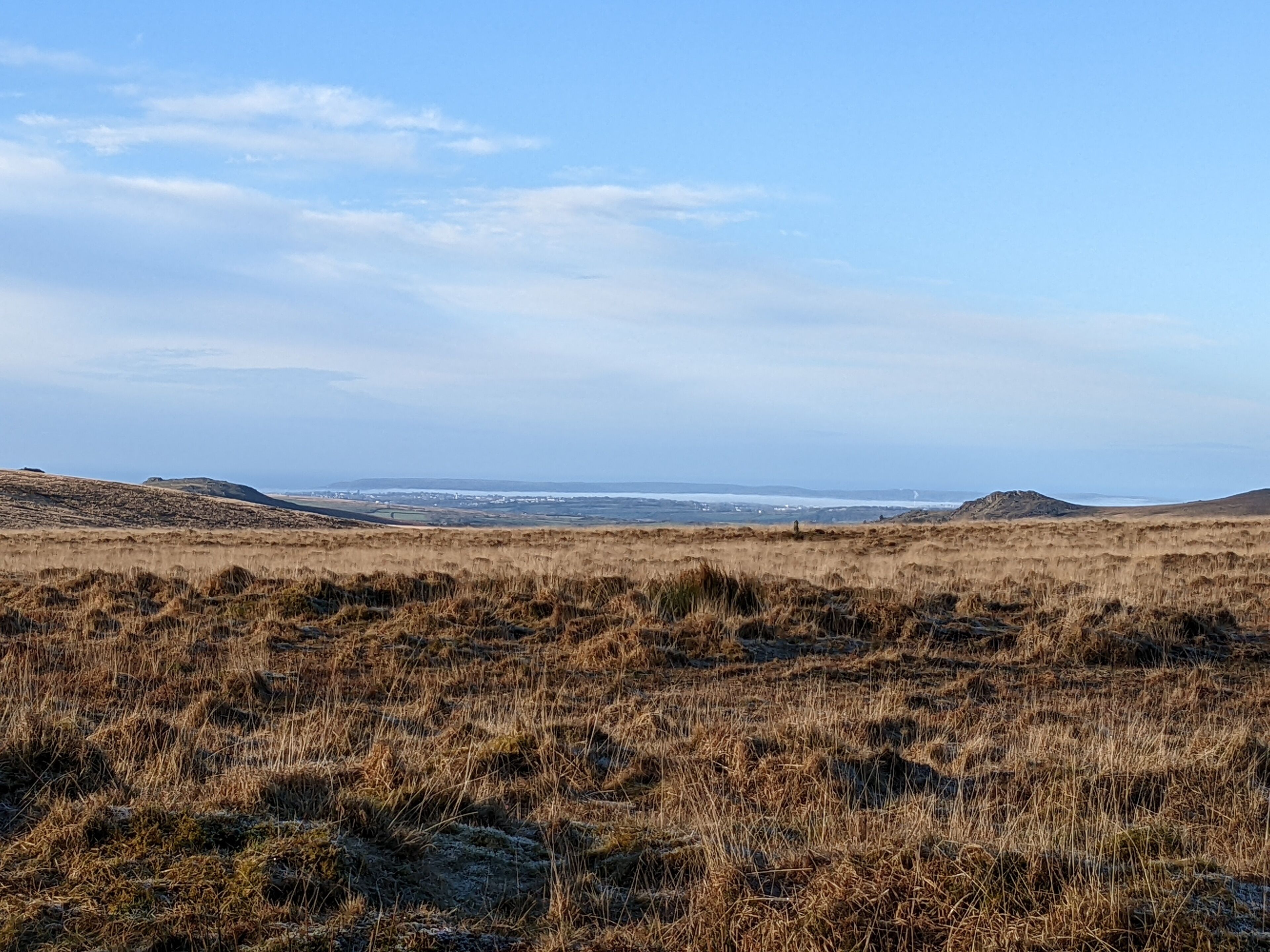 A wide, open landscape with a flat terrain and distant hills.