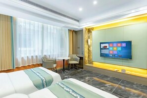A hotel room with a bed, a TV, a desk, and a chair. - Pingyi to This Inn Travel Inn (Pingyi)