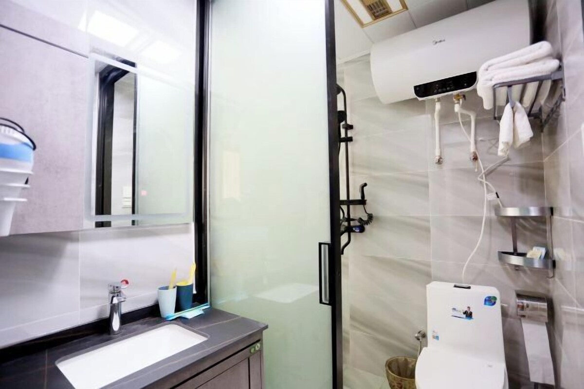 A modern bathroom with a glass shower enclosure, a built-in sink, and a towel rack.