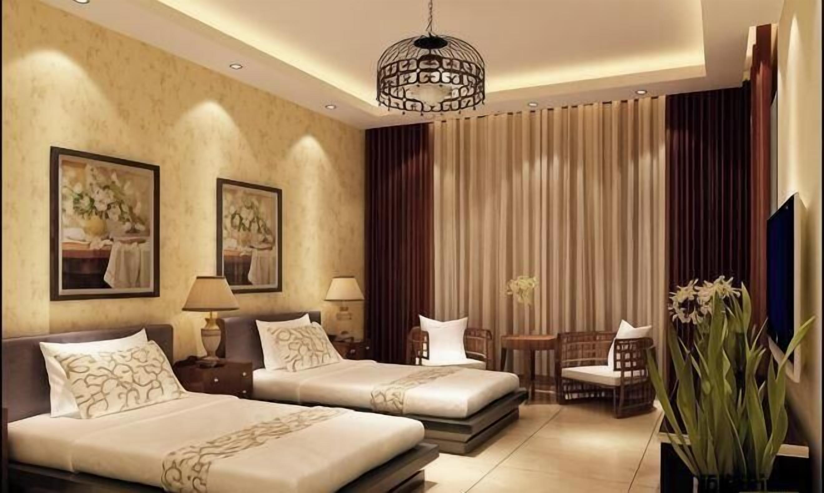 A hotel room with two beds, a chandelier, artwork on the walls, a TV, and a large window with curtains.