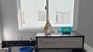 Una pequeña cocina con ventana, un lavabo y una encimera.