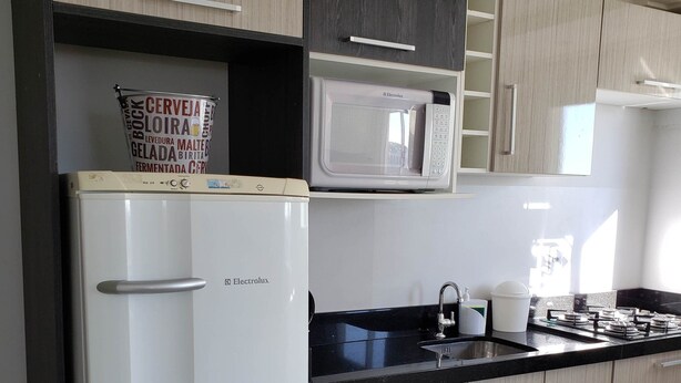 Una cocina moderna con refrigerador, microondas y estufa a gas.
