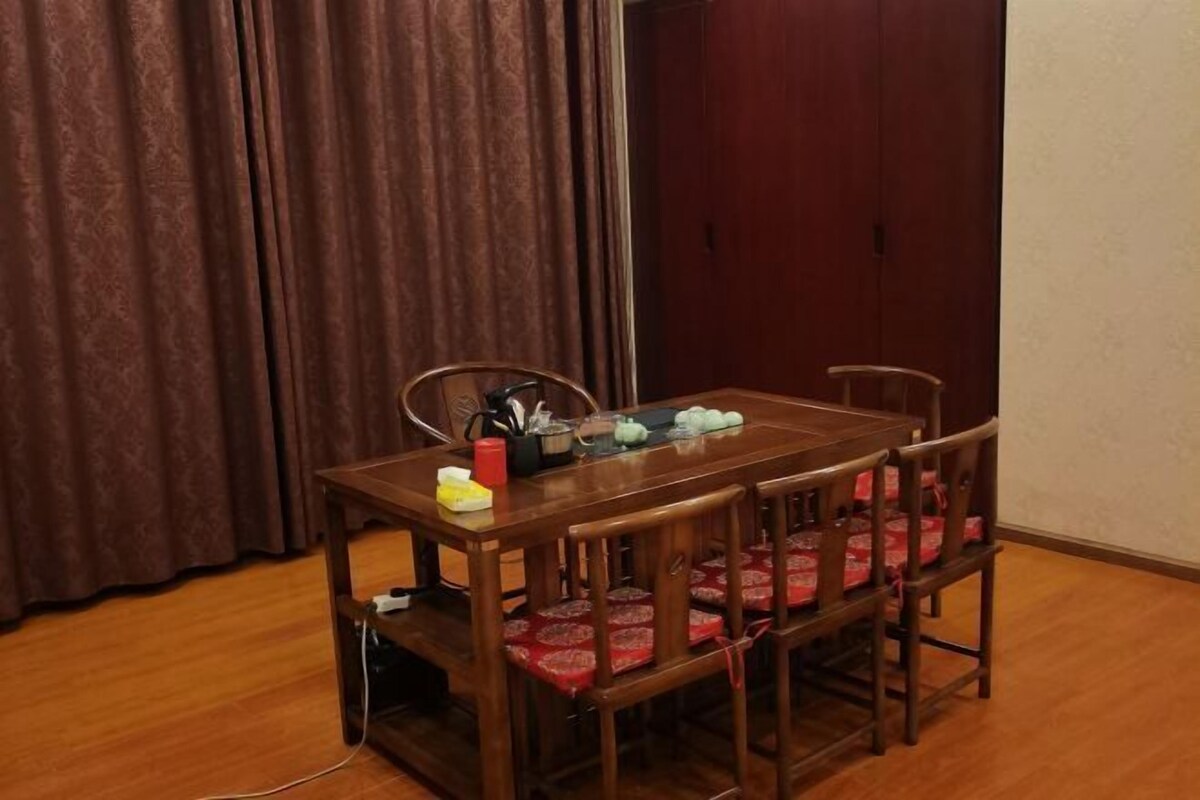 A dining table with chairs, a power strip, and a curtain in the background.