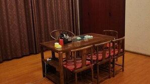 A dining table with chairs, a power strip, and a curtain in the background.