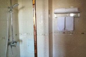 A bathroom with a shower, a towel rack, and a toilet. - Sun City Business Hotel (Yongren)