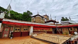 Un edificio tradicional con varios niveles, un toldo rojo y un patio amurallado.