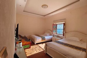 Une chambre avec deux lits, une télévision, une table de chevet et une fenêtre donnant sur un paysage agréable.