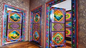 Una habitación con piso de madera y puertas coloridas y ornamentadas con diseños tradicionales.