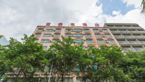 Hotel de vários andares com fachada rosa e muitas janelas.