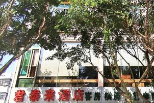 Un hotel rodeado de árboles, con un letrero en caracteres chinos.
