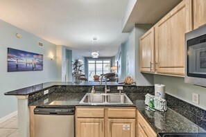 A modern kitchen with granite countertops, stainless steel appliances, and wooden cabinets. - Beachfront Condo w/Pool, Hot Tub & Beach Chairs Included (Panama City Beach)
