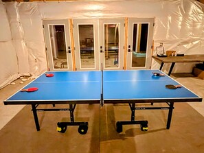 Une table de ping-pong avec deux raquettes, une balle de tennis de table et une raquette de tennis de table.