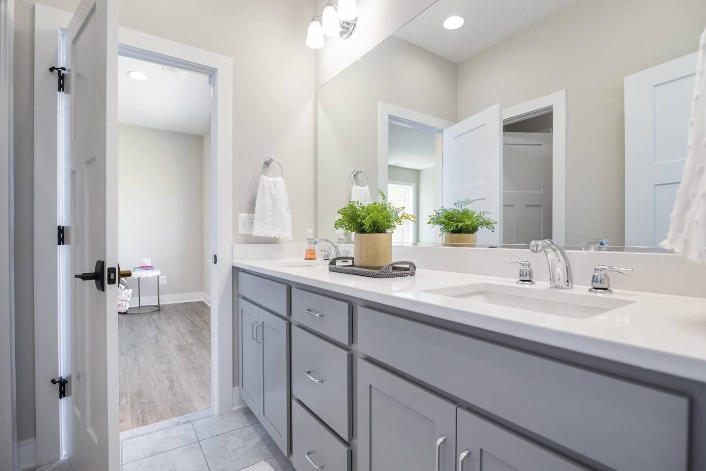 Une salle de bain moderne avec un grand meuble-lavabo, un miroir et deux éviers.