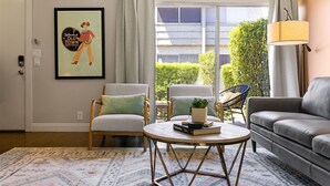 A living room with a sofa, two armchairs, a coffee table, and a framed welcome sign. - Scott Place - Amazing location, heated pool, vibrant space awaits! (Scottsdale)