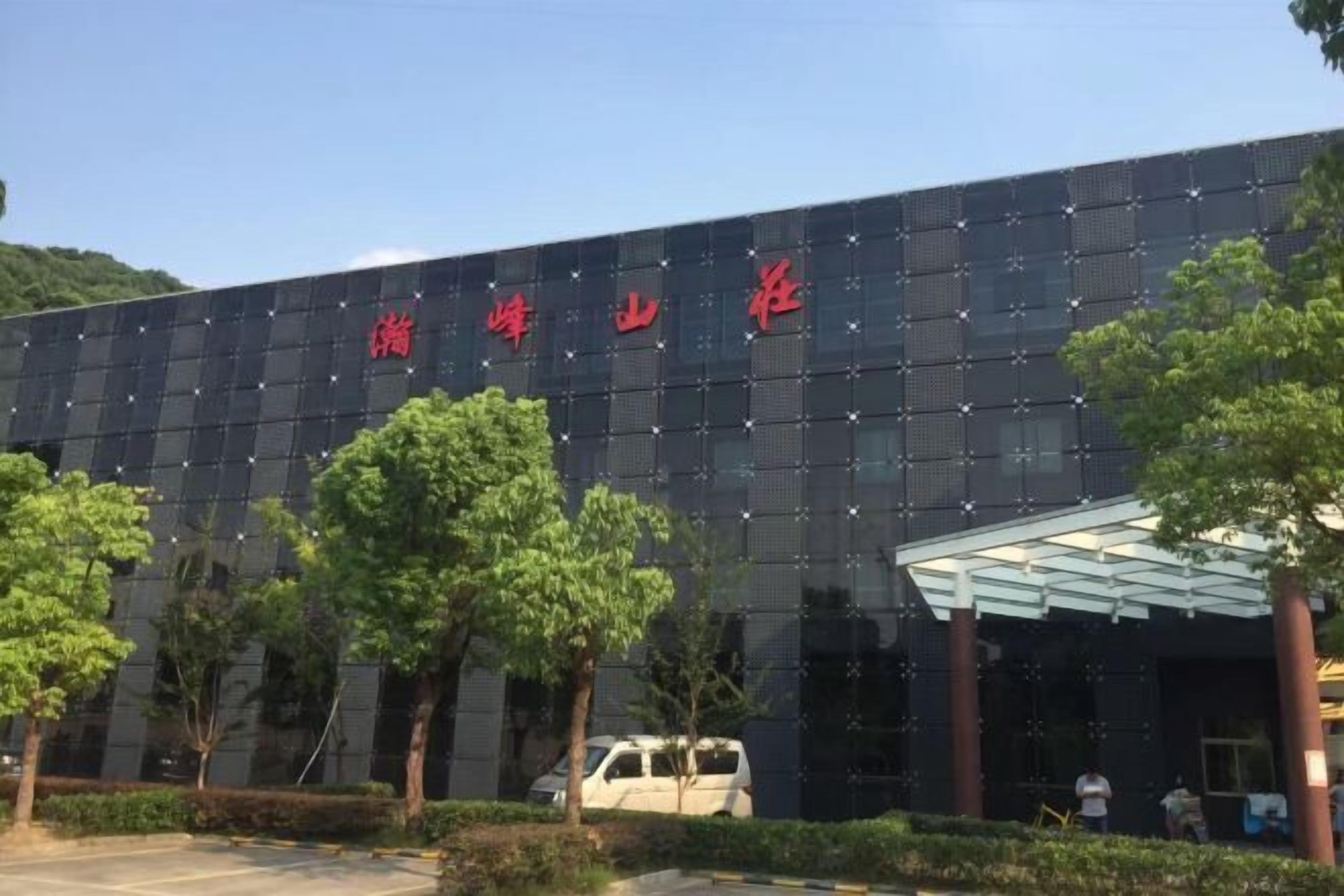 Un bâtiment à la façade sombre et à l’enseigne rouge.