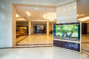 A lobby with a reception desk, a large aquarium, and a chandelier. - Borrman (hangzhou xianghu) (Hangzhou)