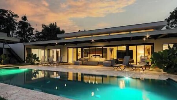 A modern house with a swimming pool, large windows, and outdoor seating. - Casa Arena Volcano View Villa (Fortuna)