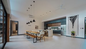 A modern kitchen with a central island, pendant lighting, and a ceiling fan. - Casa Arena Volcano View Villa (Fortuna)