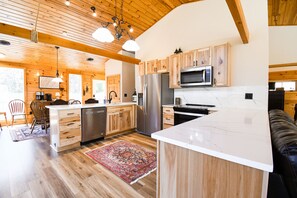 Enjoy cooking in this well-lit kitchen with stainless steel appliances and a comfortable seating area.