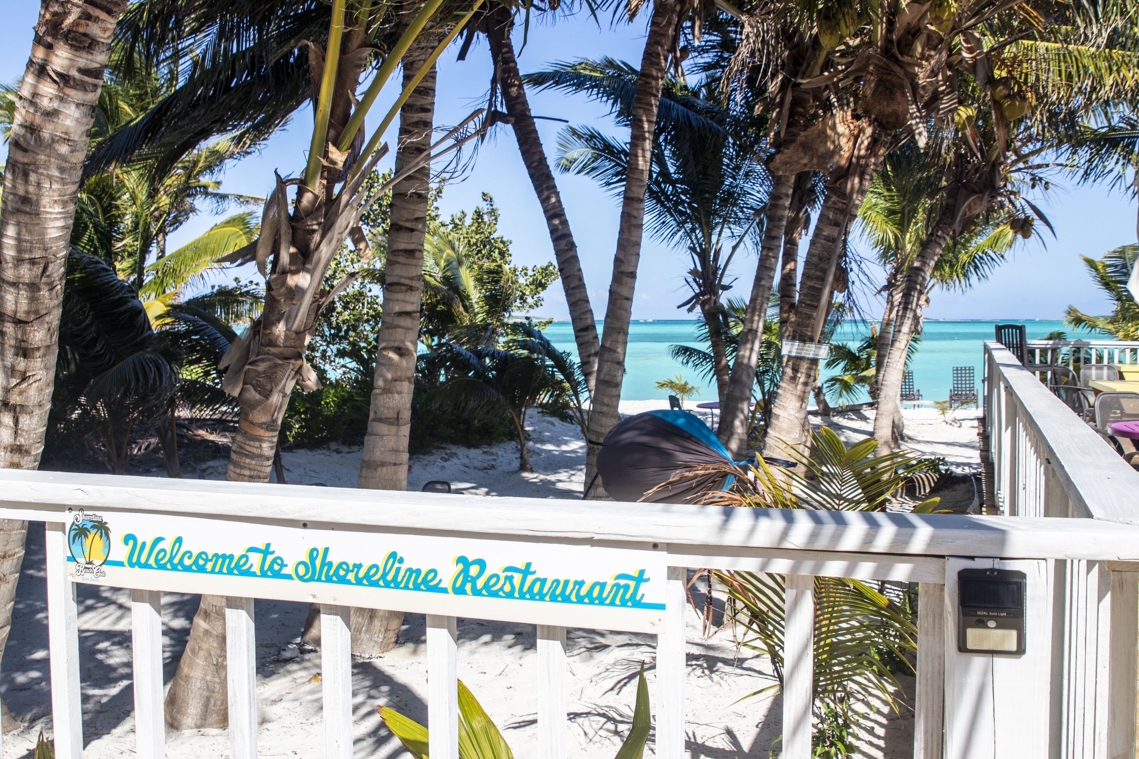 A beachside view with a sign welcoming to Shoreline Restaurant.