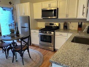 Enjoy cooking in this well-equipped kitchen with a refrigerator, microwave, and stove, and dine at the adjacent table for two.