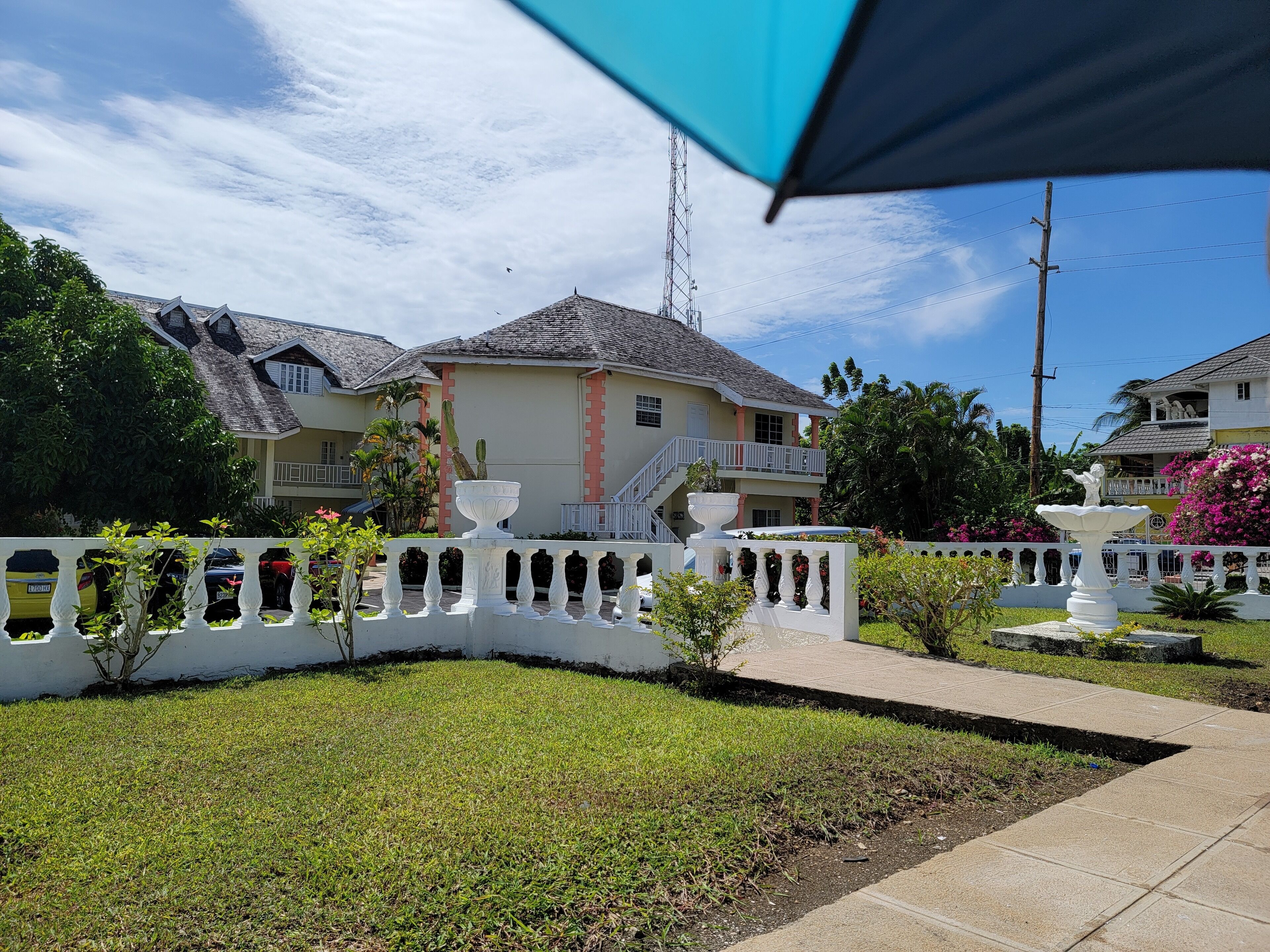 A residential area with houses, a white fence, and a garden.