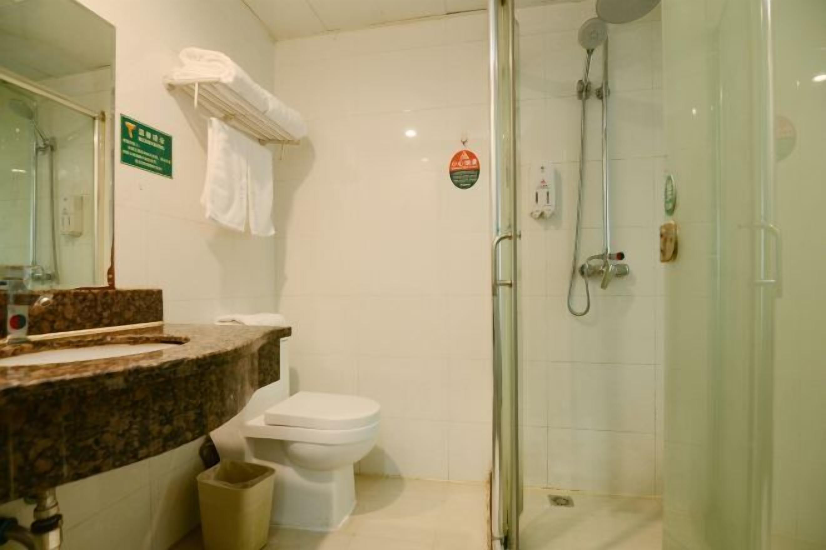 A bathroom with a shower, toilet, and sink.