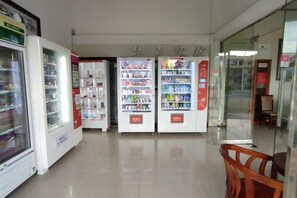 A corridor with vending machines and a glass door leading to another area. - Huachen Business Hotel (Wan'an)