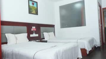 Una habitación de hotel con dos camas, un ventanal amplio y un cuadro enmarcado en la pared.