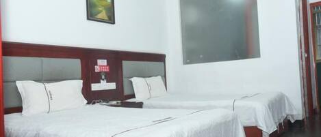 Una habitación de hotel con dos camas, un ventanal amplio y un cuadro enmarcado en la pared.
