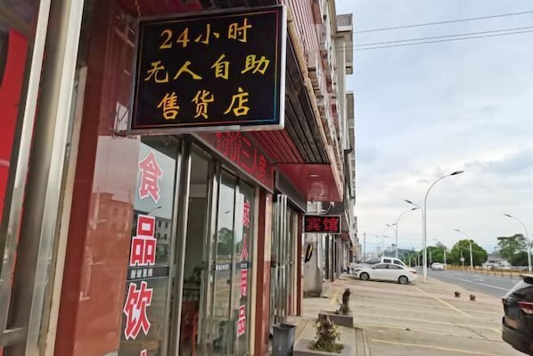 Ein Schaufenster mit einem Schild, das anzeigt, dass es sich um einen Supermarkt mit Selbstbedienung rund um die Uhr handelt.