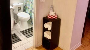 A bathroom with a toilet, a shower curtain, a towel rack, and a small potted plant. - Nice clean apartment 5 minutes from subway (Toronto)