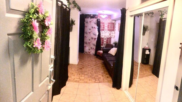 A hallway with a mirror, a door with a floral wreath, and a patterned curtain. - Nice clean apartment 5 minutes from subway (Toronto)