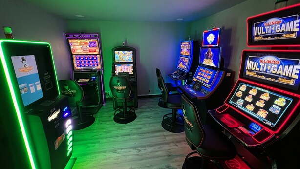 A gaming area with multiple slot machines and a neon-lit sign for VIP Lounge. - Budget Host Inn (Gilman)