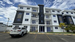 Um edifício de vários andares com um estacionamento à frente.
