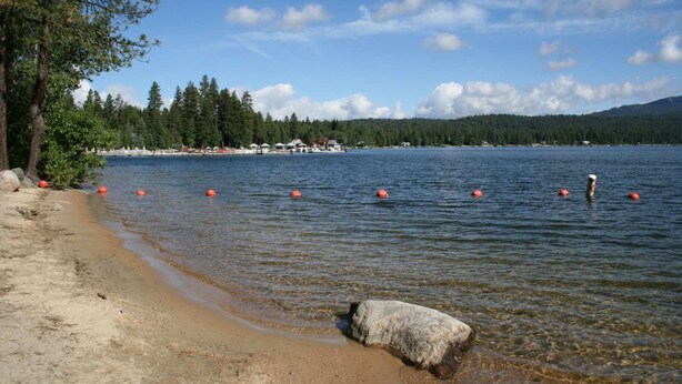 A lakeside beach with clear water, a sandy shore, and several orange buoys. - Moose Meadows Escape in McCall - dog friendly & 1 bed/1 bath on each of 3 floors (McCall)