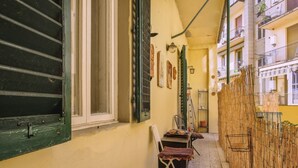 A narrow corridor with a chair, a table, and a bamboo fence. - Myosotis - Sweet Dreams in Florence (Firenze)