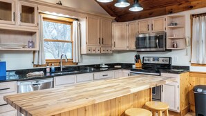 A kitchen with wooden cabinets, a central island with stools, a microwave, and a stove. - 3 Bedroom, 3.5 bath home in The Galena Territory (Galena)