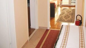 A bedroom with a bed, a clock, and a view of the balcony. - waterfront apartment family friendly, ground level (Dubrovnik)