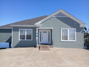 A single-story house with a front door, two windows, and a visible street address sign. - The Lily Pad (Lake Providence)