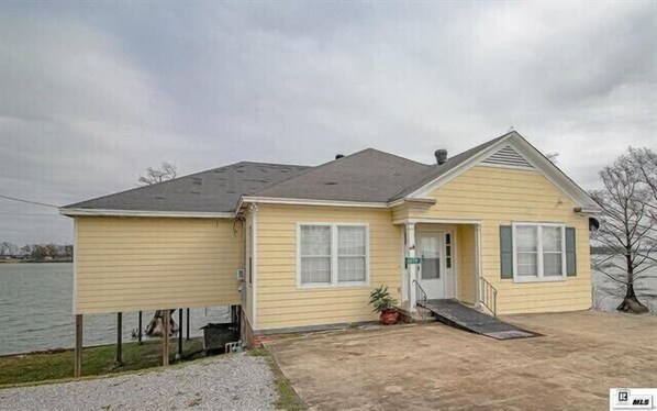 A single-story house with a front porch, a small entryway, and a ramp leading to the door.