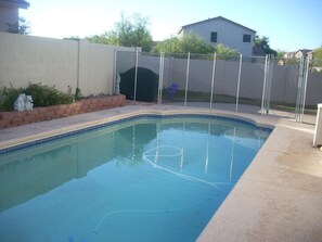 Relax by the rectangular pool surrounded by a concrete deck and a low wall.