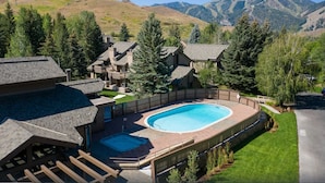 Zona residencial con piscina, varias casas y montañas al fondo.