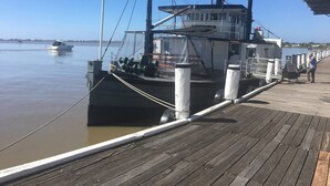 A docked ferry with a cabin structure, a wooden walkway, and a calm water body in the background. - Riverport Retreat - Pet Friendly, close to the river, free Wifi + linen included (Goolwa South)