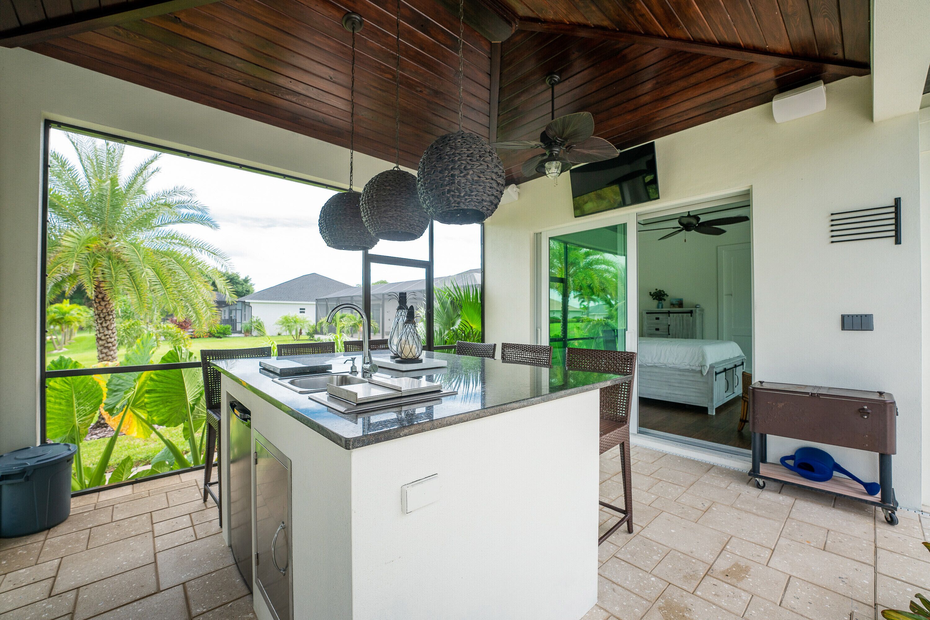 A kitchen with a large island, a dining area with chairs, and a view of a garden.