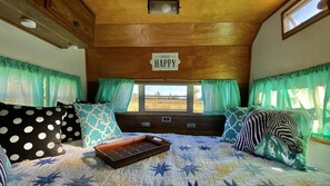 Relax in a serene space with a large bed, star-patterned quilt, and a view of a peaceful field.