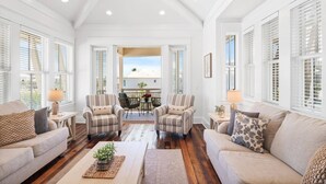 A spacious living room with two sofas, two armchairs, a coffee table, and a dining table with chairs. - Breathtaking Home w/Private Pool, Walk 2 Beach w/Beach Wagon, Pools, Hot Tub, Tennis - Destin Pointe (Destin)