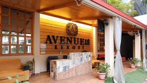 Una recepció amb façana de fusta i un rètol que diu 'Avenues Resort'.